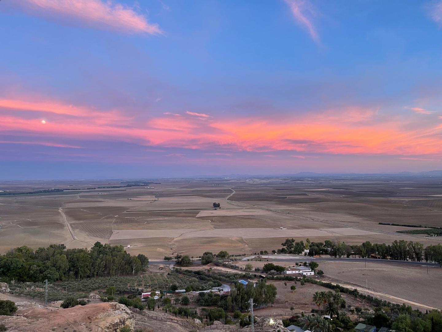 Moon over pink and lavender sunset, vast flat plains of Extremadura meseta, Spain