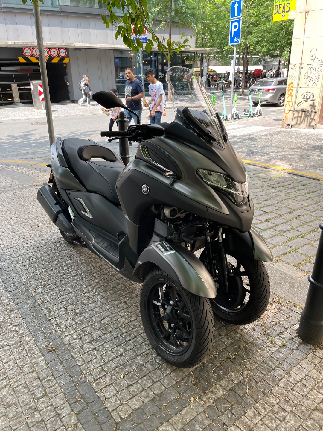 Yamaha Tricity 300 three-wheel scooter parked on cobblestones, Prague city center